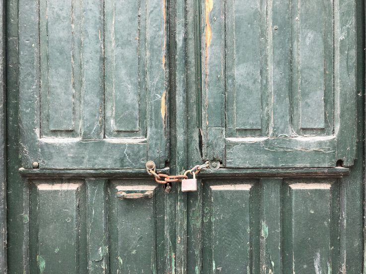 squatters in spain green door with padlock